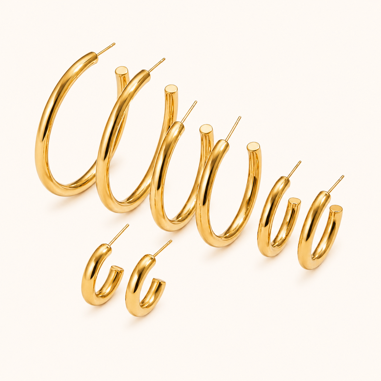 Set of gold hoop earrings on a white background